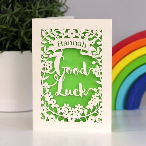 Papercut personalised Good Luck card. Cut from cream card with a bright green background. Shows the words good luck surrounded with flowers and a banner for the name. - A5 / Bright Green