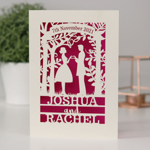A laser cut anniversary card that features the silhouettes of a couple, and is personalised with a date in a banner at the top and the names of the couple over three lines of text at the bottom - A6 (small) / Shocking Pink