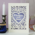 A personalised papercut wedding card featuring the date, the names "Christina and James" inside a heart and the words "On your wedding day" surrounded by floral details and two tiny birds inside a heart.