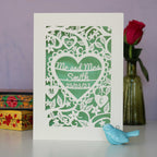 Personalised laser cut wedding cards featuring flowers and leaves, Mr and Mrs Smith and the date inside a heart.