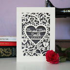 A cream and grey wedding card, personalised with the couple's name and date of wedding. 