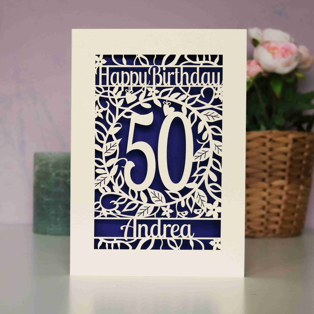 A personalised birthday card with an age and a name. Violet insert shows through the cut card.