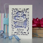 Laser cut personalised cupcake birthday card.  Cupcake has a topper which can be personalised to the birthday person's age, with their name underneath. Cut from cream card with a lilac insert paper.