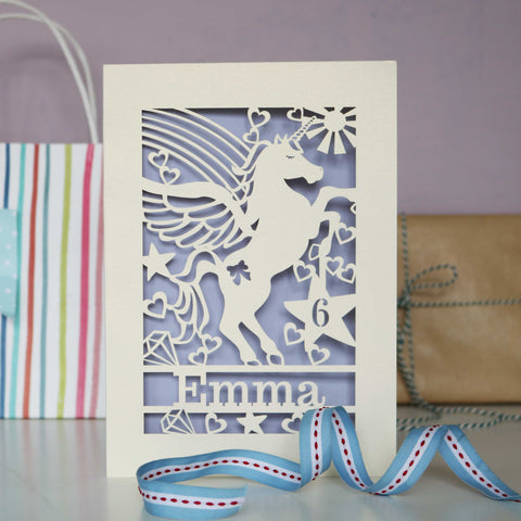 Image shows cut out birthday cards with a unicorn and personalised with a name and age - A5 / Lilac