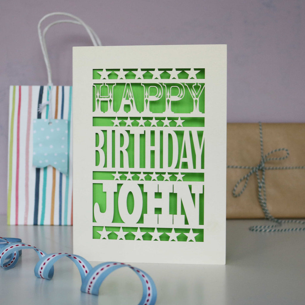 A cream laser cut birthday card personalised with a name. 