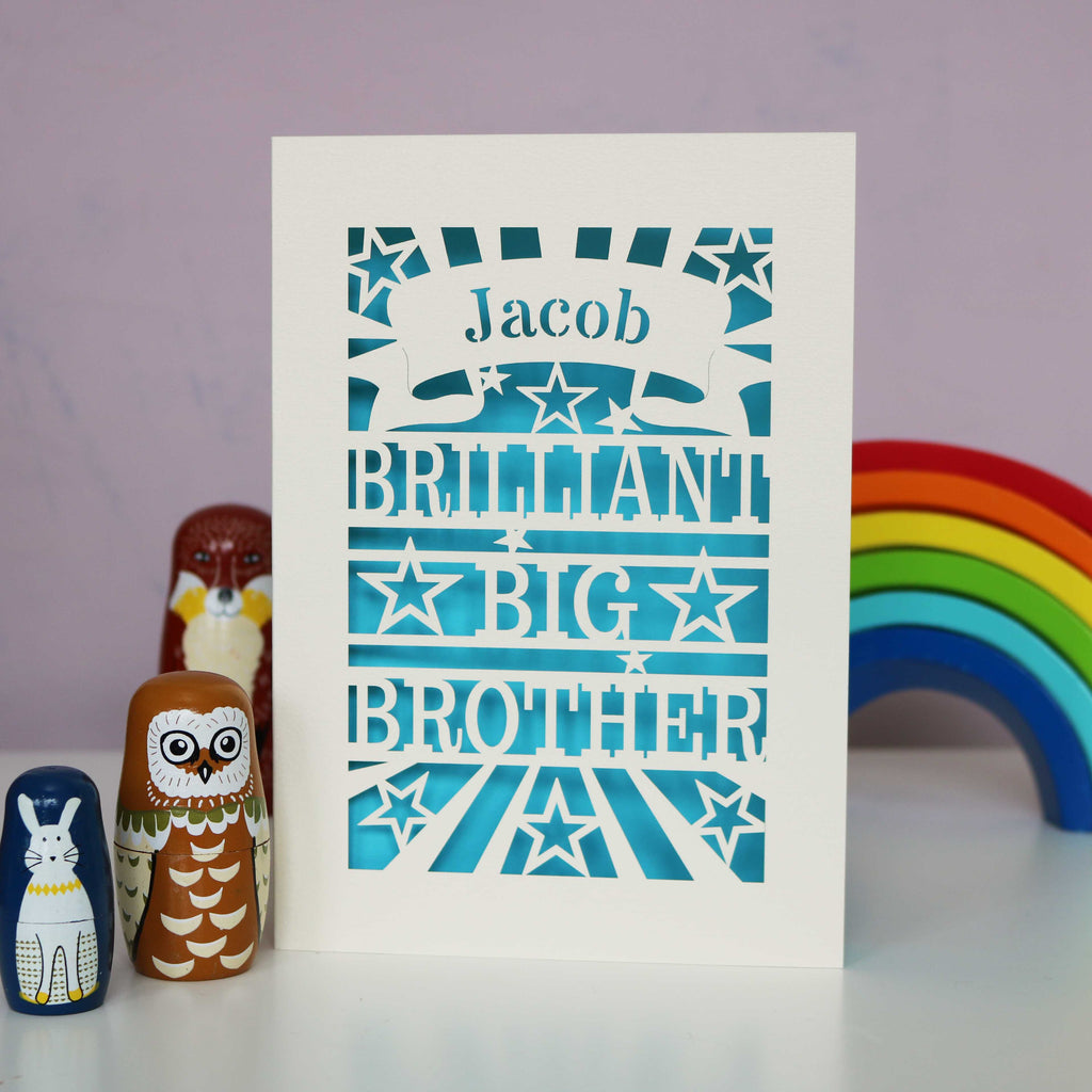 A laser cut big brother card, personalised with a name in a banner and the words "Brilliant Big Brother"