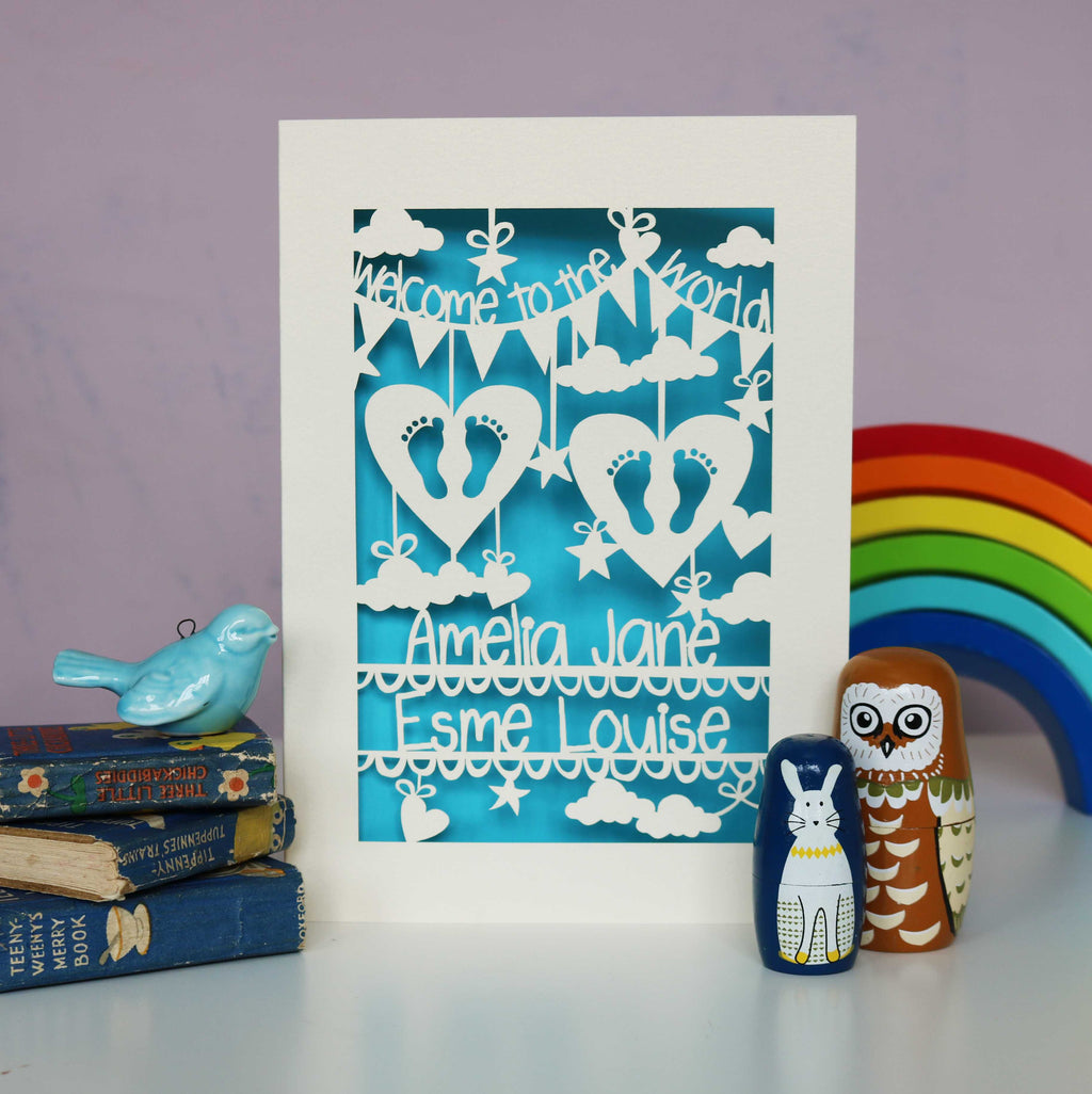 Two sets of tiny feet cut out from two hearts on this lovely Welcome to the world twins card. Shown laser cut from cream card with a peacock blue insert and personalised with the babies names.