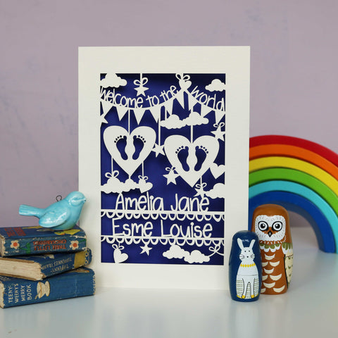 Elegant welcome to the world twins card. Featuring 2 hearts with cut out feet, clouds, stars and hearts. Lines across the bottom for the babies names. This one is cut from cream card and has a dark blue insert. - A5 / Infra Violet