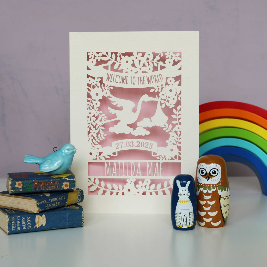A cream and pink "Welcome to the World" personalised new baby card.