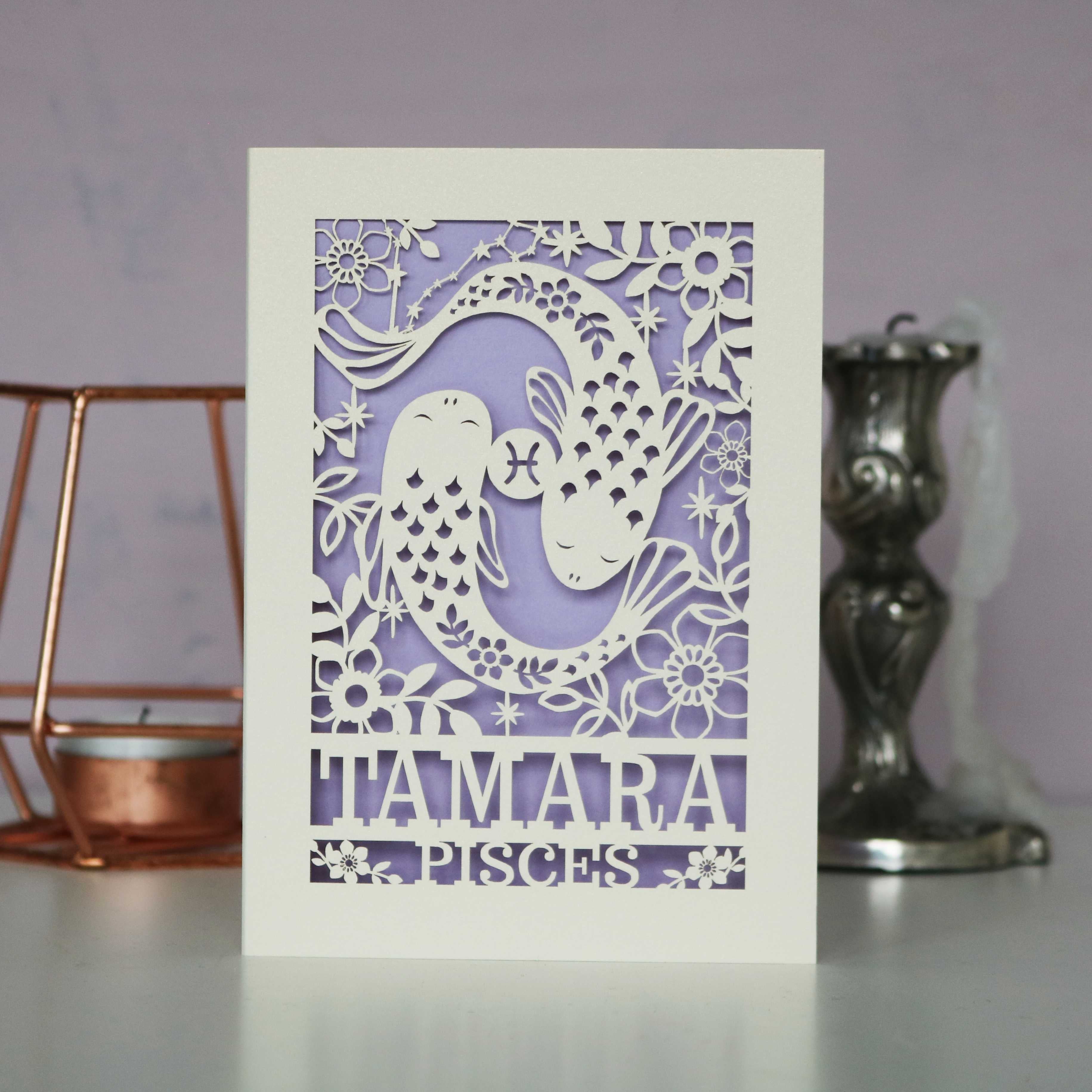 A personalised birthday card with a papercut design featuring the Pisces constellation and a fish symbol.