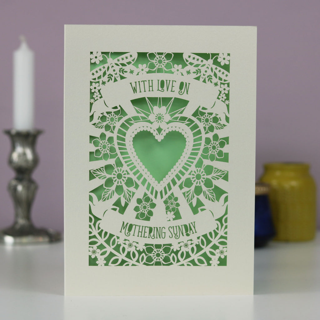 A cream and light green cut out Mother's Day card that says "With love on Mothering Sunday