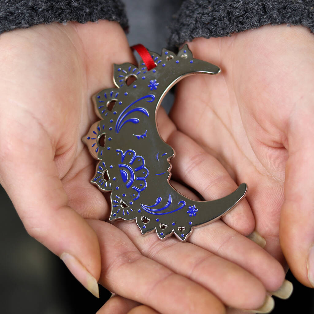 A silver and blue crescent moon Christmas tree ornament