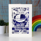 A laser cut baby card, gender neutral and personalised. Design shows a vintage pram surrounded by a floral border.
