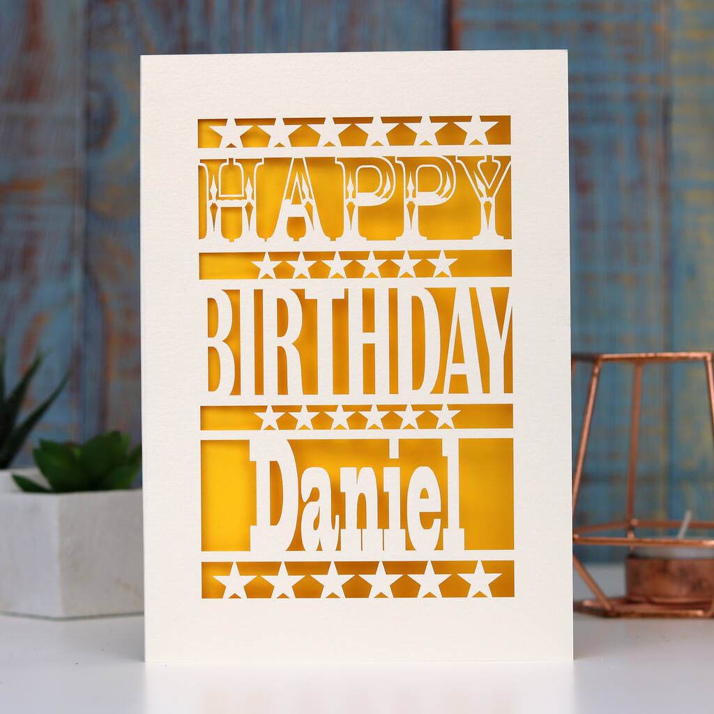 A birthday card personalised with a name and laser cut from cream with yellow behind. 