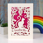 Gorgeous papercut birthday card featuring a cat and a balloon. Can be personalised with age and name. Laser cut from cream card with a shocking pink insert paper.