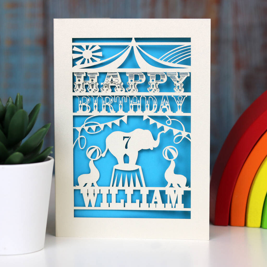 Fun circus themed personalised birthday card for child.  Cut from cream card with a bright blue background.  Personalise with a name and an age.