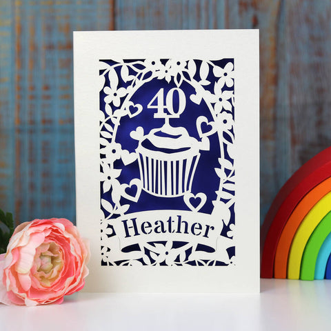 Papercut birthday card showing a cupcake and age topper. Cut from cream card and finished with a dark blue insert paper. Personalise with name and age. - A5 / Infra Violet