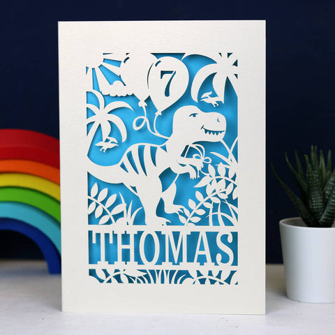 A boy's birthday card with a dinosaur on it. Laser cut cards cut from cream with a blue paper backing - A5 (large) / Peacock Blue