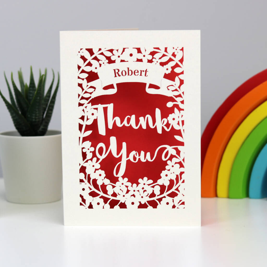 Gorgeous cream papercut card with a red background.  Shows a banner across the top to personalise with a name and "Thank you" in large script surrounded with flowers.