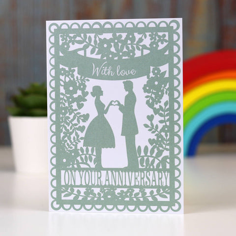 An anniversary card with silhouettes of a man and woman surrounded by flowers and leaves.  - 